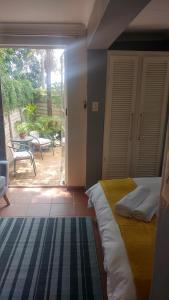 1 dormitorio con cama y vistas a un patio en Love Joy Peace Cottage, en Pretoria