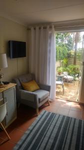 a living room with a couch and a sliding glass door at Love Joy Peace Cottage in Pretoria