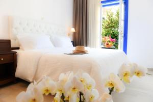 a bedroom with a bed with a hat and white flowers at Armata Boutique Hotel in Spetses