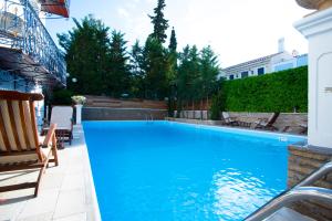 a swimming pool with blue water in a yard at Armata Boutique Hotel in Spetses