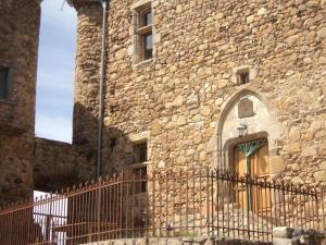 an old stone building with a gate in front of it at le Donjon de la Reine Margot in Beaumont