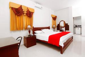 1 dormitorio con 1 cama con manta roja en Hotel Versailles Internacional, en Guayaquil