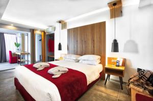 a hotel room with a bed, desk, and nightstand at Capsis Astoria Heraklion in Heraklio