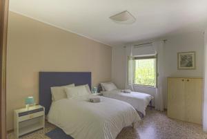 a bedroom with two beds and a window at Monteleto House.. dove Pace regna in Gubbio