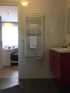 a bathroom with a sink and towels on a towel rack at AUX PETITS BAGANAIS in Lacanau +20 photos