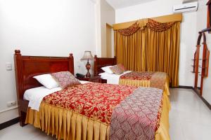 A bed or beds in a room at Hotel Versailles Internacional