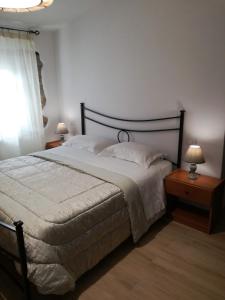 a bedroom with a large bed and two night stands with lamps at Civico 4 in Bolsena