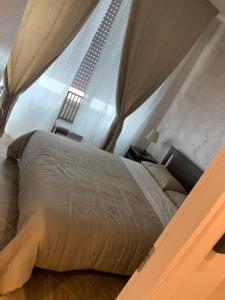 Bett in einem Zimmer mit einem großen Fenster in der Unterkunft Domus Monasteire in Pagani
