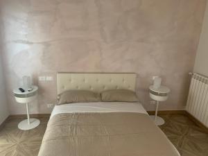 um quarto com uma cama grande e duas mesas de cabeceira em Domus Monasteire em Pagani