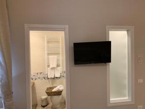 uma casa de banho com uma televisão de ecrã plano na parede em Domus Monasteire em Pagani