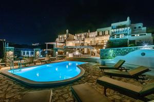 a swimming pool in front of a house at night at 9 Muses Villas Mykonos in Ornos