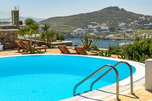 a blue swimming pool with a view of a city at 9 Muses Villas Mykonos in Ornos