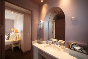 a bathroom with a sink and a large mirror at Le Cavendish in Cannes
