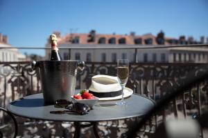 a table with a bottle of champagne and a hat and glasses at Le Cavendish in Cannes