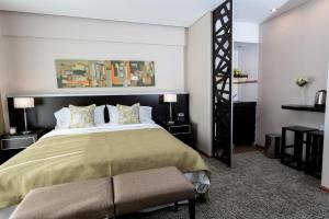 a bedroom with a large bed with a green bedspread at Konke Buenos Aires Hotel in Buenos Aires +51 photos