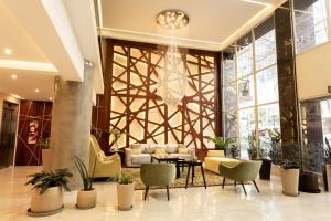 a lobby with chairs and tables and a chandelier at Konke Buenos Aires Hotel in Buenos Aires