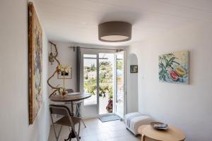 a living room with a table and a window at Absolument Levant in Île du Levant