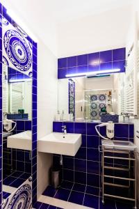 un bagno piastrellato blu con due lavandini e uno specchio di Sirentum Suite a Sorrento