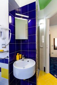 uma casa de banho com um lavatório e uma parede de azulejos azuis em Sirentum Suite em Sorrento