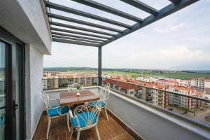 a balcony with a wooden table and chairs and a view at Kavala Hotel in Bursa