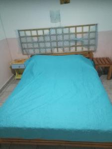 a bed with a blue blanket on top of it at Anemoxadi Apartments in Siviri