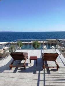 聖內德爾賈的住宿－House Marina 30m from the sea，一个带桌子和长椅的庭院和大海