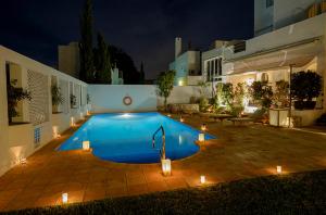 a swimming pool with lights in a backyard at night at miKasa Agua Amarga & SPA in Agua Amarga