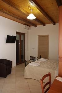 a bedroom with two beds and a flat screen tv at Hotel Maremonti in Ioppolo