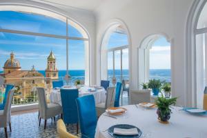 a dining room table with chairs and a large window at Tramonto d'Oro in Praiano
