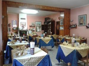 un restaurant avec des tables en tissu bleu et blanc dans l'établissement La Lucciola Albergo Ristorante, à Tagliacozzo