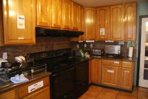 a kitchen with black appliances and wooden cabinets at Adelaide Hostel in San Francisco