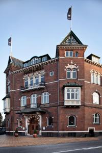 a brick building with a clock on the front of it at First Hotel Grand in Odense
