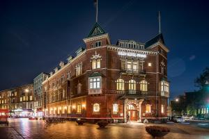a large brick building at night with lights at First Hotel Grand in Odense