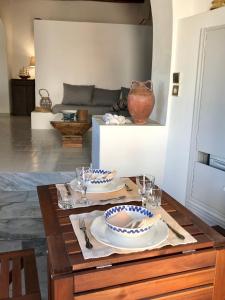 una sala de estar con una mesa con platos y vasos. en Spacious Paros, Lefkes house with awesome view, en Kampos
