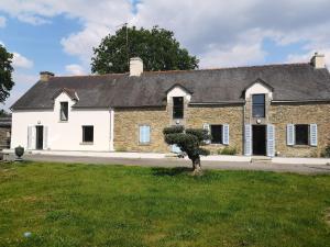 an old brick house with a tree in front of it at LA GALNAIS in Ploërmel