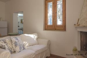 a living room with a white couch and a window at Casa della Valle Gentile in Mattinata