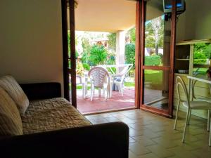 a living room with a door open to a patio at Verdemare Sardegna Due Villette in Villasimius