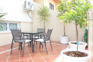 聖瑪麗亞港的住宿－Casa Valdelagrana Playa，庭院配有桌椅和盆栽树木。