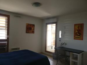 sypialnia z łóżkiem, biurkiem i oknem w obiekcie Le Village w Marsylii