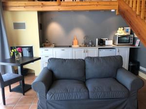 a living room with a couch and a kitchen at Appartement piscine in Tonneins