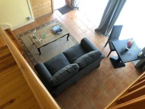 ein Wohnzimmer mit einem schwarzen Sofa und einem Tisch in der Unterkunft Appartement piscine in Tonneins