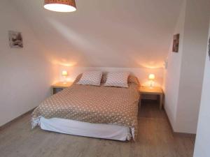 a bedroom with a bed and two lamps on two tables at Les Chambres de Pascaline in Arrest