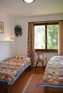 a bedroom with two beds and a window at Monami Apartments Klosters, Apt. Solavers No 1 in Klosters