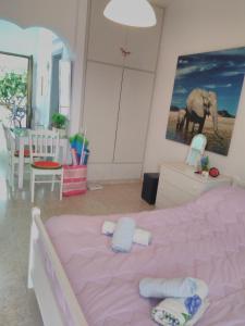 una camera da letto con un letto rosa e asciugamani di Yiota's Cute Studio a Paphos