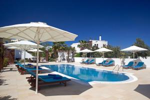 a swimming pool with umbrellas and chairs and a pool at Arlene Boutique in Mesaria