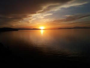 a sunset over a large body of water at Almyra seaside in Perdika