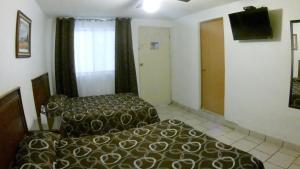 a hotel room with a bed and a television at Hotel San Luis in San Luis Potosí