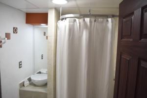 a bathroom with a shower curtain and a sink at Hotel San Luis in San Luis Potosí +26 photos