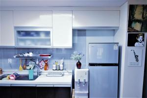a kitchen with a white refrigerator and a sink at Work Life Balance Busan Station in Busan