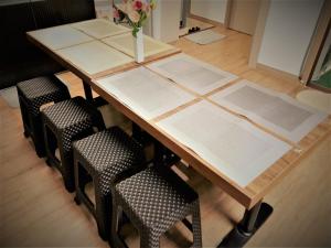 a wooden table with four chairs and a vase of flowers at Work Life Balance Busan Station in Busan